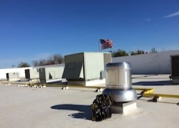 Rooftop HVAC equipment at a client facility with an American flag in background