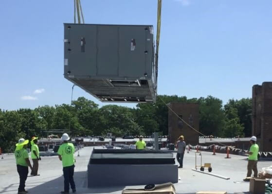Equipment being lowered onto a rooftop for a large unit installation